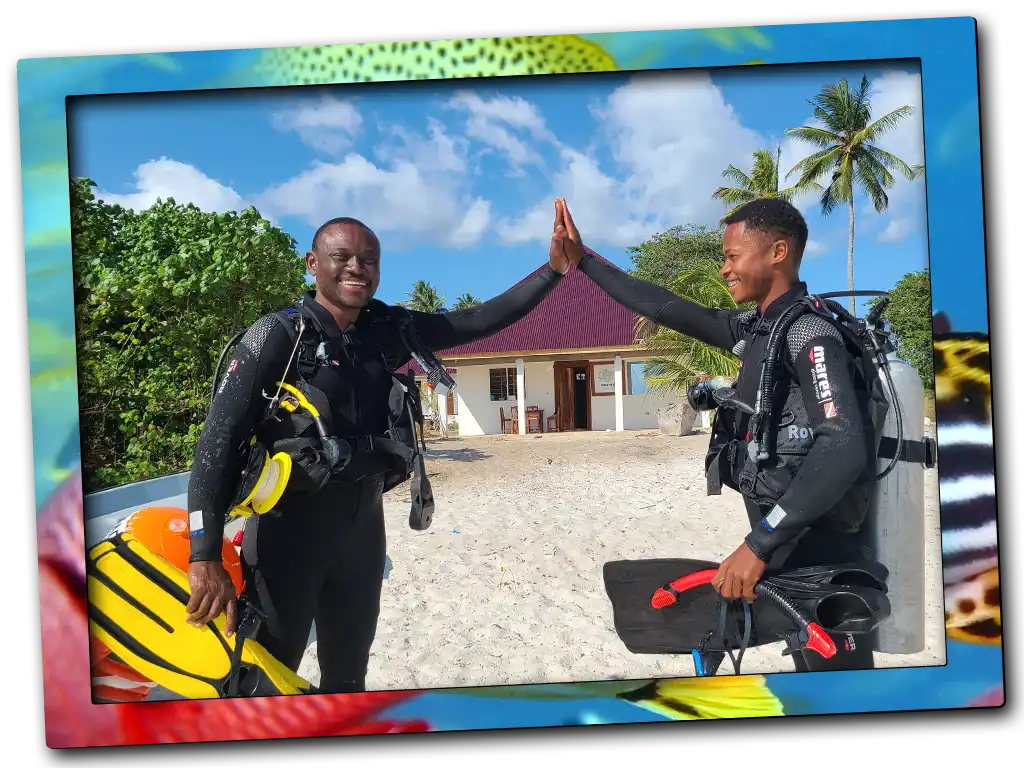 Local PADI instructor with a dive team member high-fiving at our base on Pemba Island