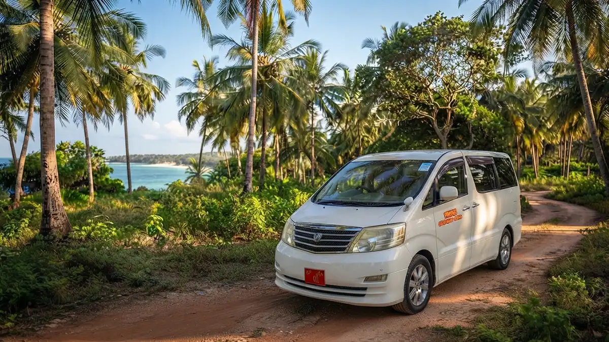 White private transfer van on a scenic coastal road in Pemba Island heading to the dive resort in Makangale